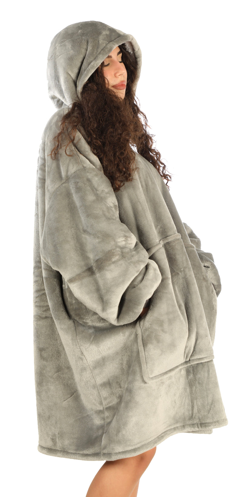 A woman standing sideways wearing a gray Cozify plush wearable blanket hoodie, showing the soft velvety texture and oversized cozy fit from the side view.